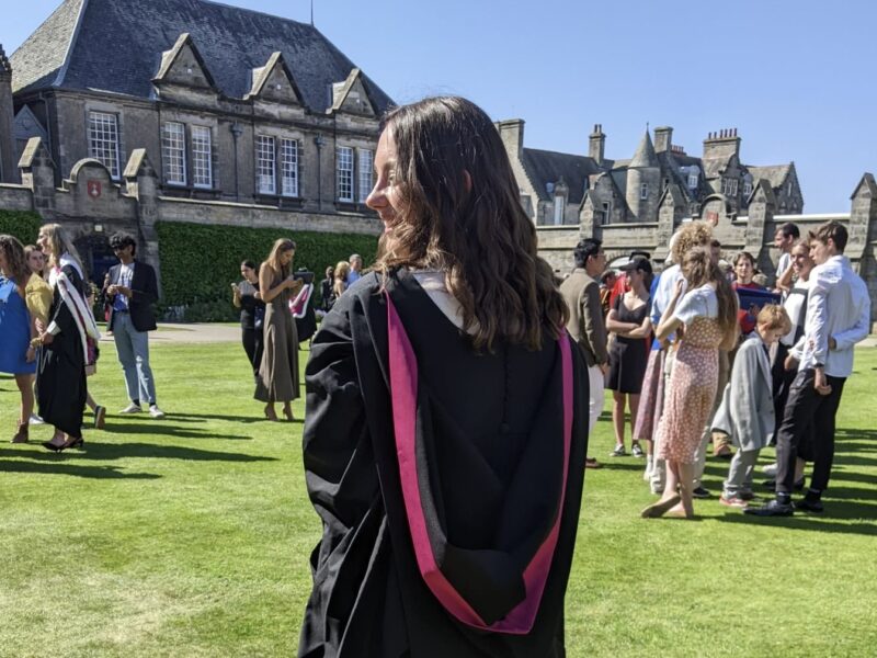 Student with back to the camera wearing a gown for graduation