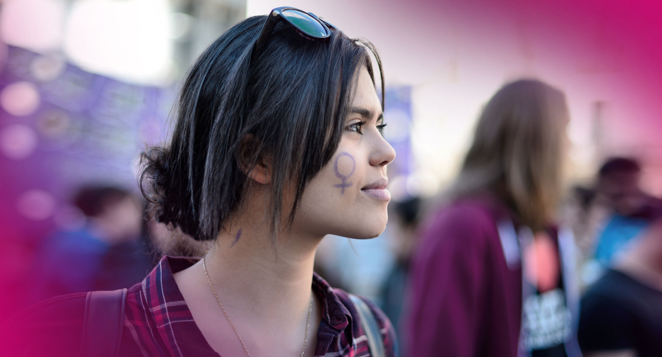 A young woman with a female symbol drawn on her face