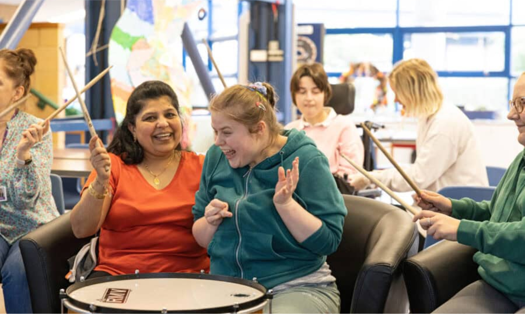Young people at a Sense activity playing with drums and percussion